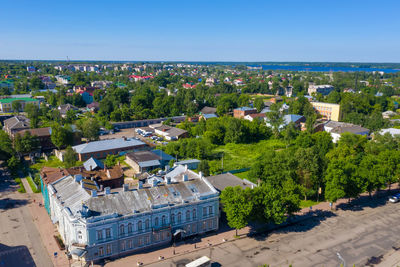 High angle view of buildings in town against clear blue sky