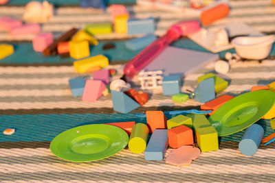 Multicolor wooden building blocks on mat in morning.