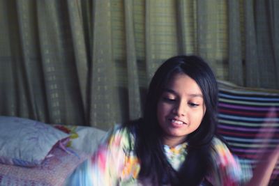 Young woman smiling while standing on bed