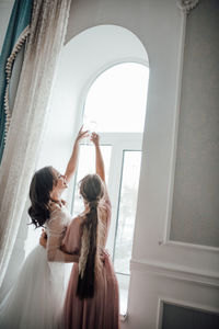 Rear view of women standing in corridor of building