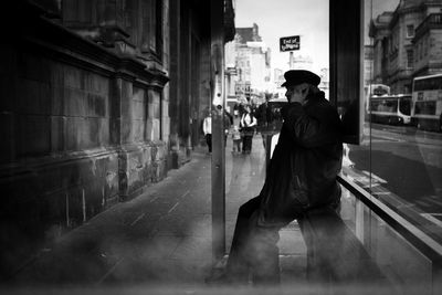 Side view of man walking on street in city