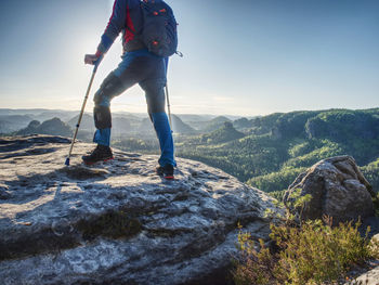 Rear view of man standing on mountain against sky