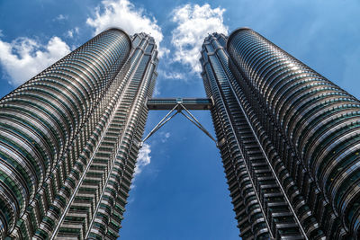 Low angle view of the petronas twin towers against blue sky