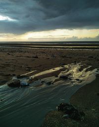 Scenic view of beach against sky during sunset