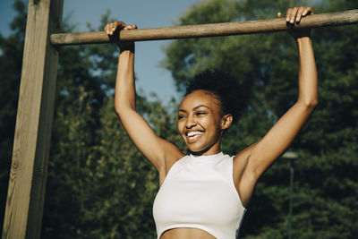 Portrait of smiling young woman with arms raised