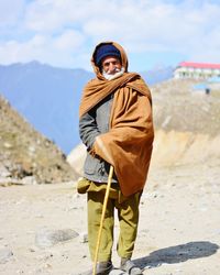 Full length of senior man standing on mountain during sunny day