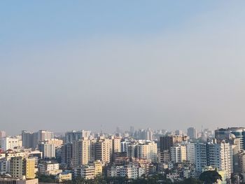 Buildings in city against clear sky