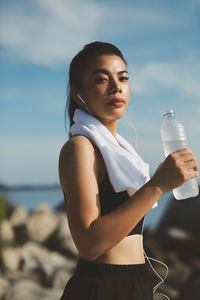 Young woman drinking water at beach