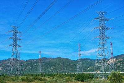 Electricity pylon on field against sky