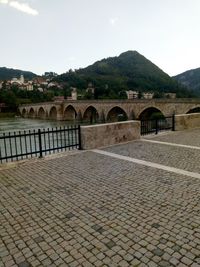 Arch bridge over river against sky