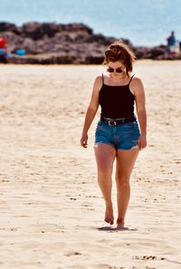 Full length of woman walking on sand at beach