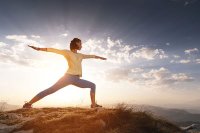 Young woman practices yoga and fitness outdoors in a beautiful mountain landscape. morning dawn