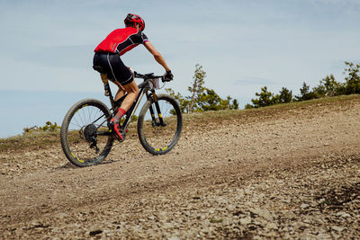 Athlete cyclist riding uphill trail on mountain bike