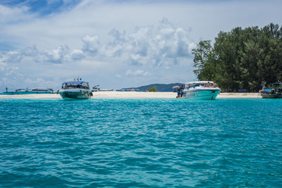 Boats sailing in sea against sky