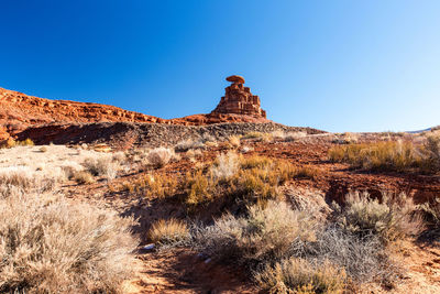 Rock formations on landscape against blue sky