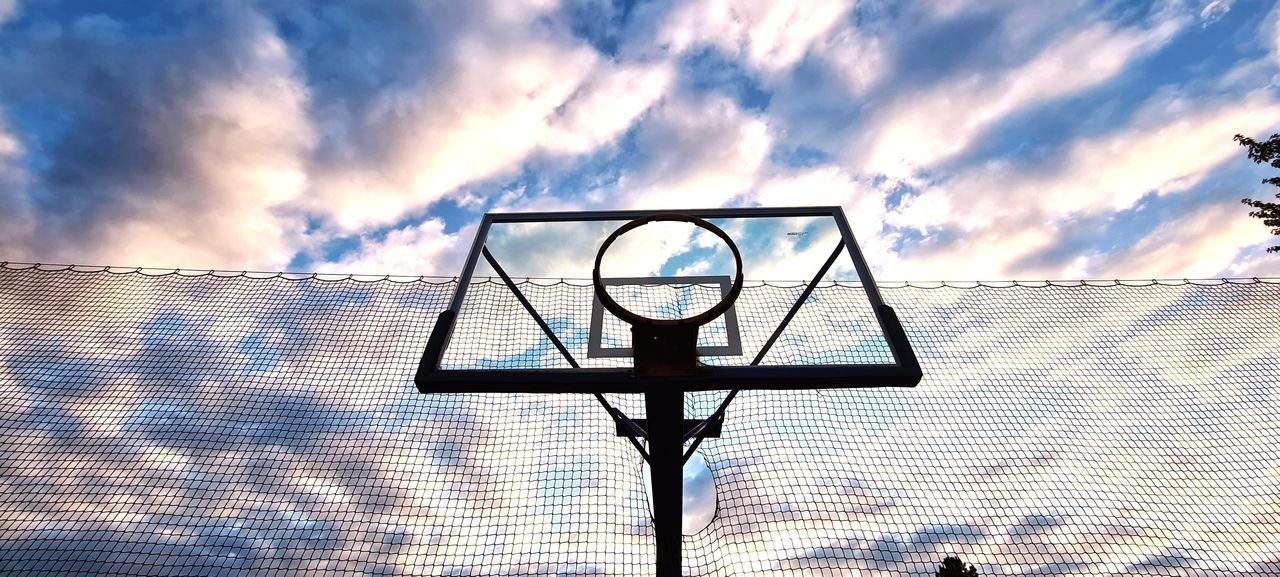 LOW ANGLE VIEW OF BASKETBALL HOOP AGAINST BUILDINGS