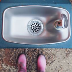 Low section of person standing in front of sink