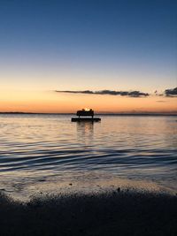 Silhouette boat in sea against sky during sunset