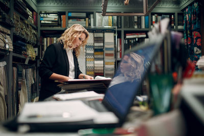 Woman reading book in library