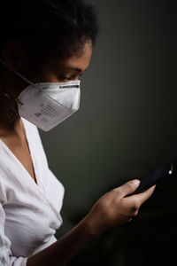 Woman with face mask using a smartphone