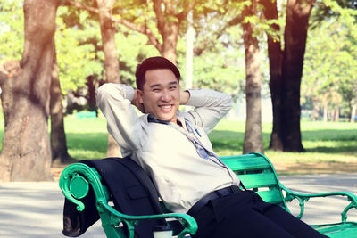 Portrait of happy man sitting in park