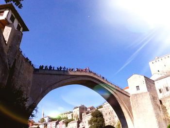 Low angle view of bridge in town against sky