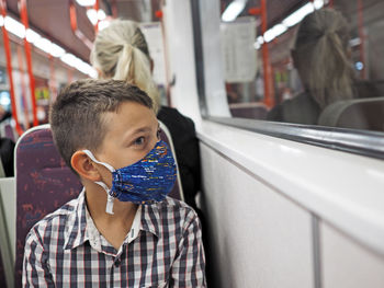 Close-up of boy looking away sitting at subway train