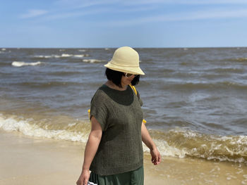 Full length of senior woman standing on beach