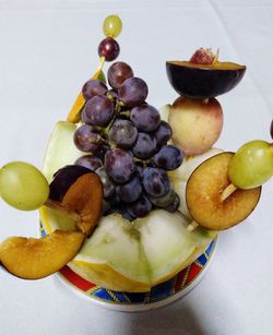 Close-up of grapes in plate against white background