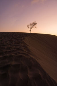 Scenic view of desert against sky during sunset