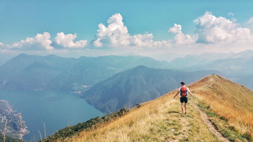 Rear view of man on mountain against sky