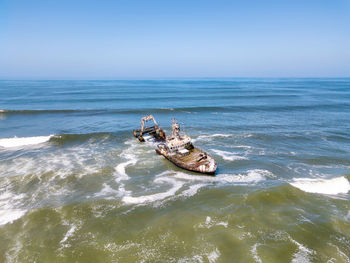 Abandoned ship in sea against sky