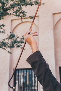 Midsection of man holding painting against wall