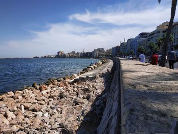Scenic view of sea by buildings against sky