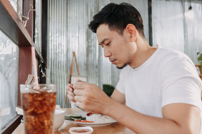 Midsection of man sitting on table at restaurant