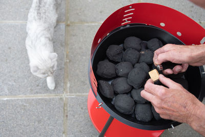 A man lights a fire with a lighter special charcoals for a barbecue