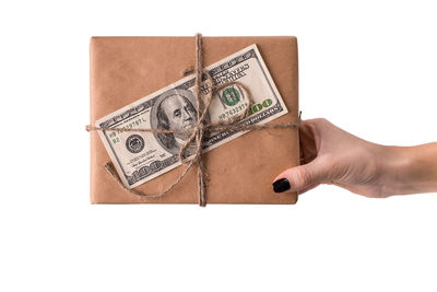 Close-up of hand holding paper over white background