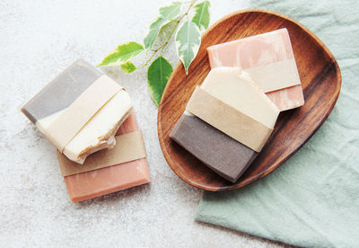 Assorted handmade soap bars and green leaves
