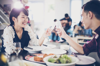 Smiling friends toasting wineglasses in restaurant