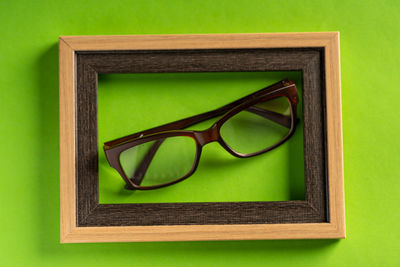 Close-up of green eyeglasses on table