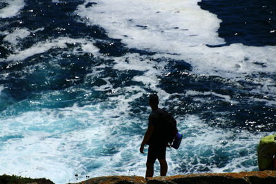 Rear view of man standing on sea shore