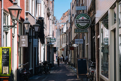 People walking on street amidst buildings in city