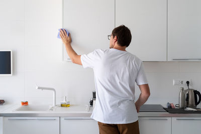 Rear view of man standing at home