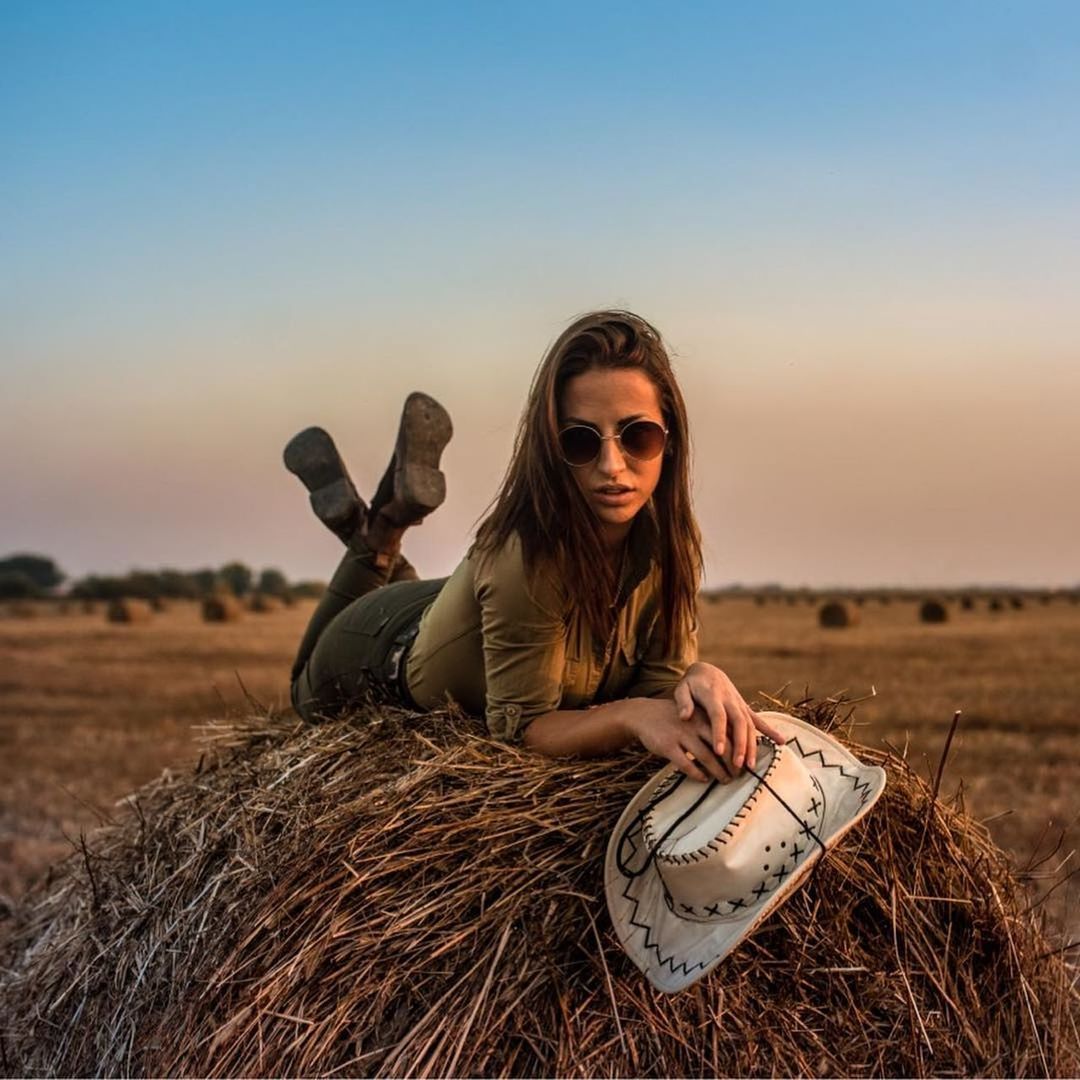 sky, young adult, nature, land, sunset, people, leisure activity, women, real people, looking at camera, adult, lifestyles, smiling, portrait, young women, clear sky, field, hay, outdoors