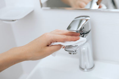 Midsection of woman washing hands in sink