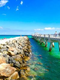 Bridge over sea against blue sky