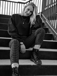 Portrait of a smiling young woman sitting on staircase