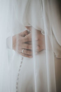 Close-up of woman hand on white curtain