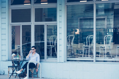 Man sitting on chair by window