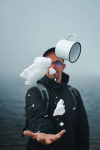 Young man looking at sea against sky